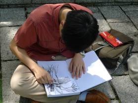A participant sketching on his book