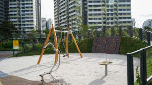 Sand play area with swings and a rock wall (west section)