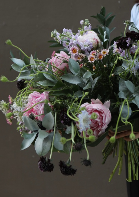 A hand tied bouquet with pink blooms and silver foliage