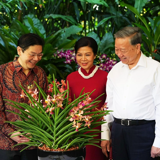 Singapore Prime Minister Lawrence Wong presenting an orchid to Vietnamese Party Secretary General To Lam and his spouse